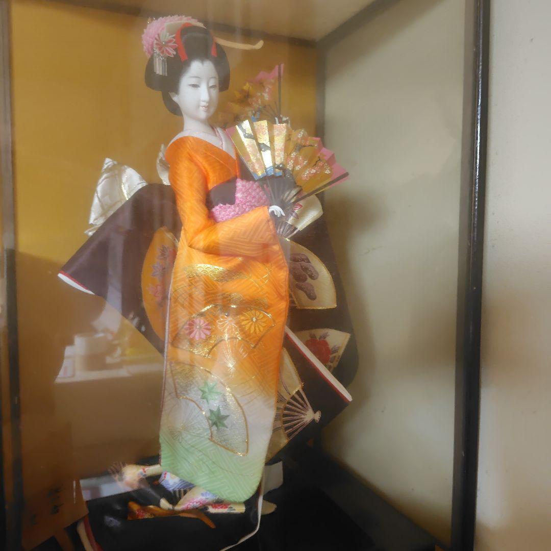 御所人形 オレンジと黒の衣装 ガラスケース入り