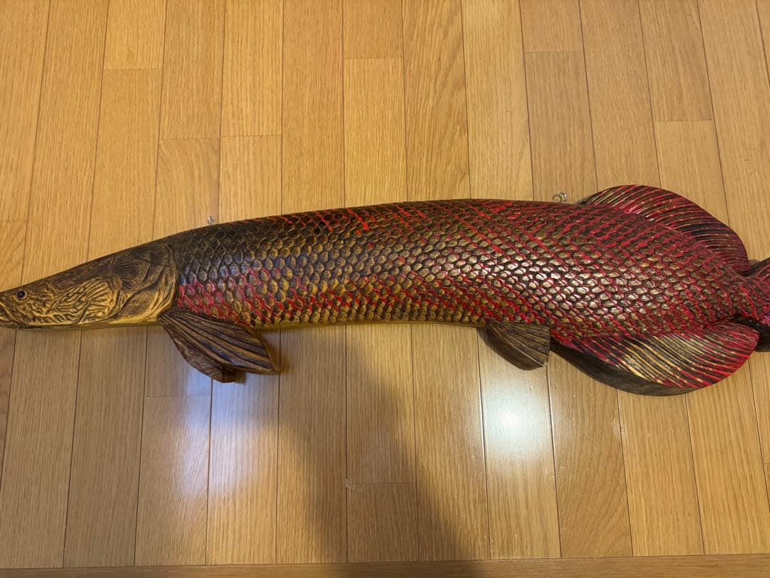 ピラルクの木製彫刻 赤と金の鱗模様