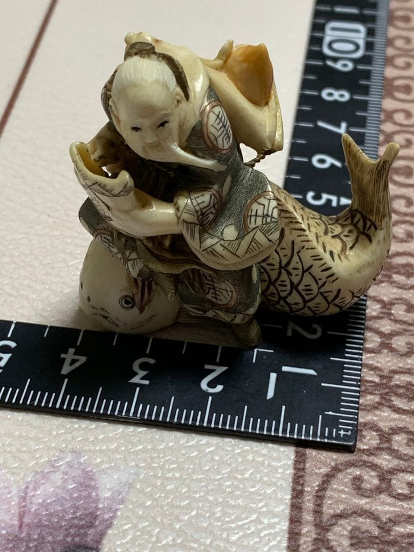 天然素材根付けアンティーク品寿老人と魚彫ってます。