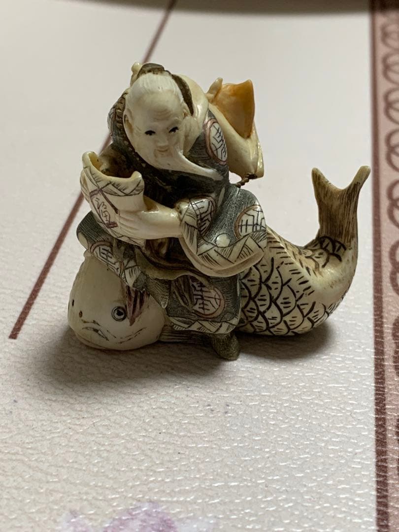 天然素材根付けアンティーク品寿老人と魚彫ってます。