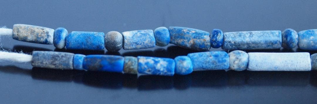 古代濃紺ラピスの管玉や丸玉をほぼ左右対称に編み、トップに斧型や多面体、80個の連