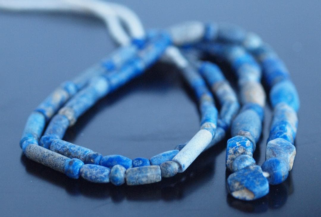 古代濃紺ラピスの管玉や丸玉をほぼ左右対称に編み、トップに斧型や多面体、80個の連