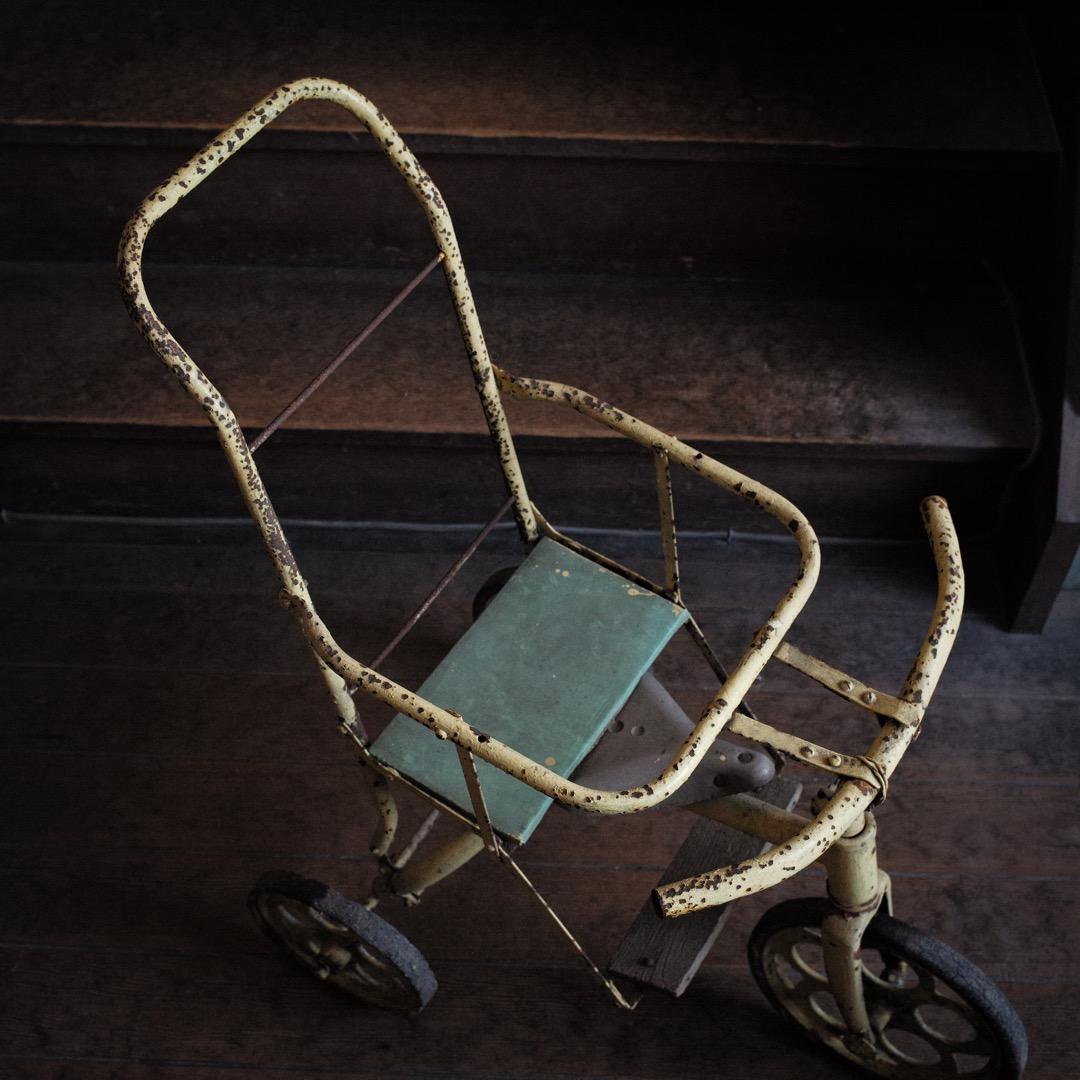 古いペンキ塗りの鉄製手押し三輪車 / 昭和時代